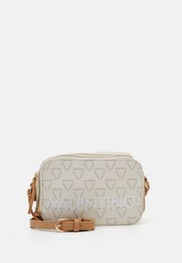 Borsa a tracolla rettangolare beige con motivo monogramma, dotata di chiusura con zip e tracolla regolabile color cuoio. Logo evidente sul davanti.