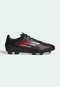 Crampon de soccer noir avec tige en synthétique texturé, rayures rouges et argentées, fermeture à lacets et crampons moulés pour l'adhérence.