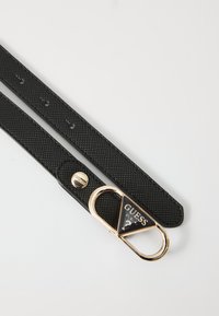 Curea texturată neagră din material sintetic, cu o cataramă din metal cu ton auriu, accentuată de un logo triunghiular și închidere tip snap.