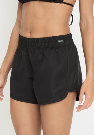 Svarte svømmebukser med elastisk midjebånd og en subtil logo. Stoffet er glatt og lett, med en kort lengde og sidespalter.