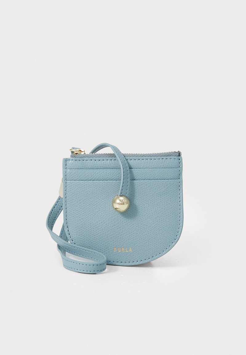 Portamonete in pelle azzurro chiaro, dalla forma rotonda, con accessori in oro, chiusura con zip e una tracolla staccabile. Presenta una texture liscia e un dettaglio con logo.