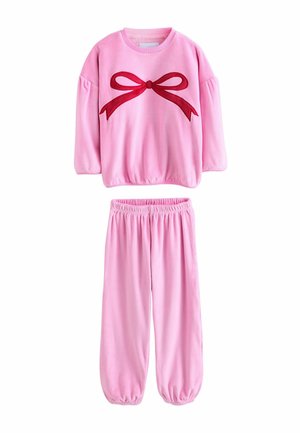 Ensemble en velours rose comprenant un haut à col rond, des manches bouffantes et un appliqué en forme de nœud rouge sur le dessus. Taille élastique sur le pantalon fuselé.