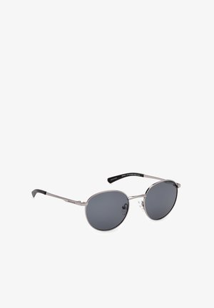 Occhiali da sole aviator metallici argento con lenti grigio scuro, caratterizzati da una montatura sottile in filo, naselli regolabili e aste nere eleganti.
