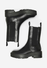 Bottines noires à tige en cuir lisse, avec des panneaux élastiques sur les côtés, des languettes de traction et une semelle épaisse crantée.