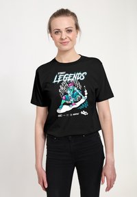 Černé tričko s barevným grafikou postavy s růžovými vlasy a tyrkysovou pletí, text zní "ULIČNÍ LEGENDY." Vyrobeno z bavlny.