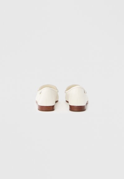 Biele kožené topánky s nízkym opätkom, zaobleným tvarom a minimalistickým dizajnom. Majú hladkú textúru a jemný detail šitia.