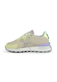 Zapatillas que presentan una combinación de tonos beige, verde claro y lavanda. Los materiales incluyen ante y malla, con una gruesa suela de goma blanca.