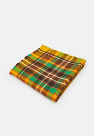 Écharpe en laine pliée avec un motif à carreaux jaune, vert, marron, orange et blanc sur fond blanc.