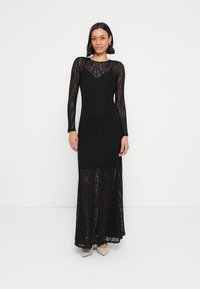 Črna čipkasta obleka z dolgimi rokavi, ki ima oprijetim korzet, tekočo krilo in prozorno spodnjo polovico. Gladek tekstura z izrazito izrezom.