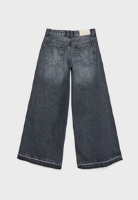 Jeans w szerokich nogawkach w ciemnoszarym dżinsie z wysokim stanem. Posiadają dwie tylne kieszenie i kontrastowe przeszycia wzdłuż dołu nogawek i kieszeni.
