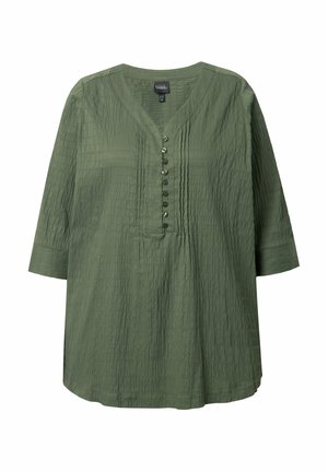Zelená tunika s texturou, má V-výstřih, tříčtvrteční rukávy a knoflíkovou légu vpředu. Obsahuje jemné vertikální sklady.