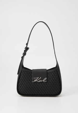 Fekete kézitáska szőtt textúrával, elegáns formával és sima bőrfelülettel. Fémes logó részlet és állítható pánt jellemzi.