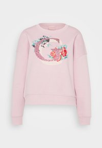Sudadera rosa con cuello redondo, que presenta un diseño floral de la letra 'G'. Tejido suave, corte relajado y puños y dobladillo acanalados.