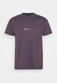 Fialové bavlněné tričko s krátkými rukávy, kulatým výstřihem a bílým kurzivním logem na přední straně. Klasický střih s hladkou texturou.