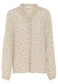 Blouse beige à manches longues avec des pois noirs, dotée d'un col en V et d'un devant à volants. Le tissu a une texture lisse ; les manches sont munies de poignets élastiques.