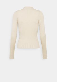 Rippensweater mit langen Ärmeln in Hellbeige und hohem Kragen. Strickstruktur, taillierte Silhouette und glatte Nähte. Keine sichtbare Markenkennzeichnung.