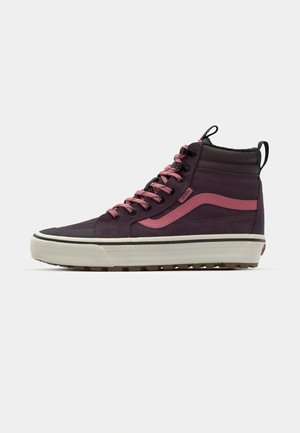 High-top sneakers in dark purple and pink, featuring a textured upper, pink side stripe, black laces, and a white outsole with a patterned grip.