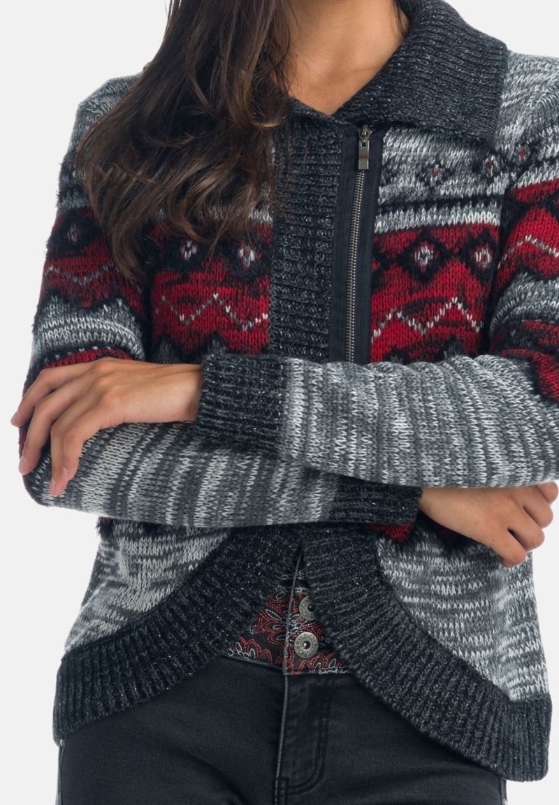 Pletený cardigan s červenými a černými geometrickými vzory na šedém podkladu, se zapínáním na zip vpředu, širokým límcem a žebrovanými manžetami a lemem.
