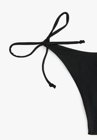 Schwarzer Bikini-Oberteil mit dreieckiger Form, ausgestattet mit einer Bindeschließe und glattem Stoff, der ein minimalistisch gestaltetes Design hervorhebt.