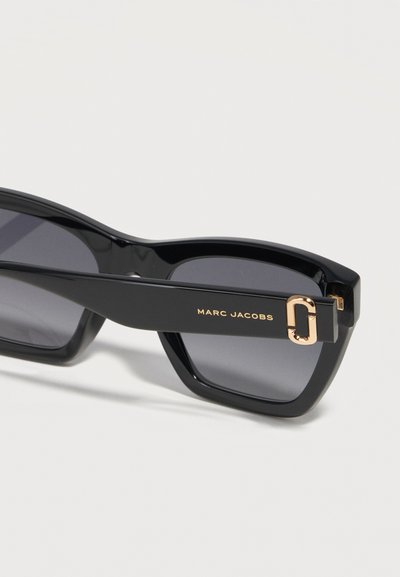 Μαύρα ορθογώνια γυαλιά ηλίου Marc Jacobs με σκοτεινούς φακούς και χρυσή λεπτομέρεια λογότυπου στο μπράτσο.