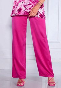 Fuchsia wijde broek gemaakt van een gladde stof, gecombineerd met bijpassende sandalen met bandjes. De onderranden zijn schoon zonder contrasterende details.