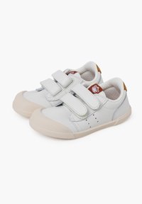 Weiße Leder Sneakers mit doppelten Klettverschlüssen, Gummi-Zehenkappe und heller Sohle. Strukturiertes Futter und kleines Logo-Detail an der Ferse.