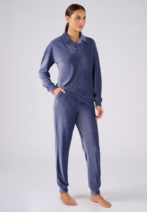 Ensemble de vêtements d'intérieur en velours d'un bleu marine profond. Haut à manches longues avec col et trois boutons, associé à un pantalon ajusté à poignets élastiques. Texture lisse.