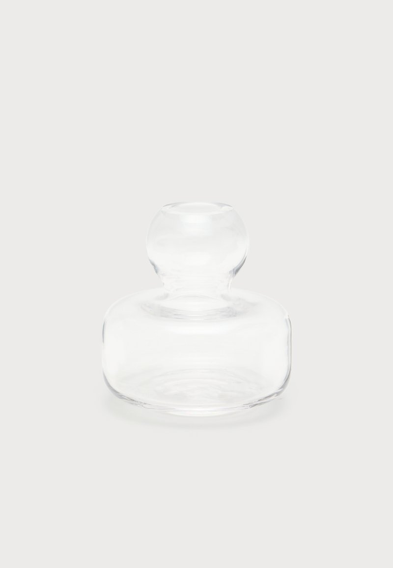 Presse-papiers en verre clair et rond avec un sommet bulbeux et une large base, présenté sur un fond clair uni.