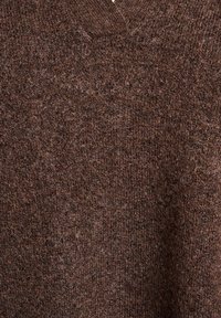 Bruine gebreide trui met een v-halsontwerp, voorzien van een textuurafwerking en variaties in tint, gemaakt van een zacht, warm materiaal.