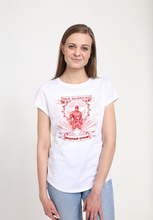 T-shirt blanche avec un design graphique rouge présentant une figure musclée et le texte "RED GUARDIAN" et "КРАСНЫЙ СТРАЖ" à l'avant. Manches courtes.