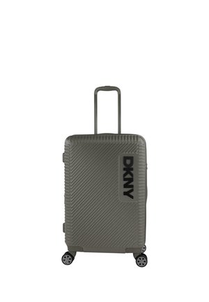 Maleta rígida en verde oliva mate con ranuras diagonales, asa retráctil y cuatro ruedas negras. Cuenta con el logo de DKNY en negro intenso.