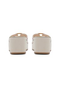 Bílé plátěné platformové sandály s hladkým povrchem a otevřenou špičkou. Mají zlatý akcent na přední straně a stabilní blokový podpatek.