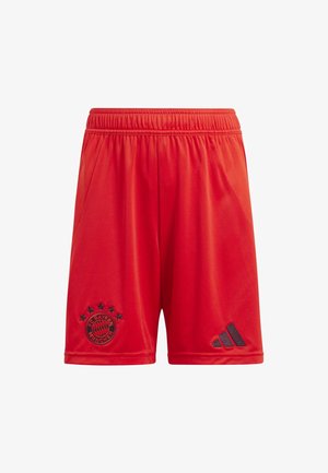 Maglia da calcio rossa del Bayern Monaco con scollo a V, dettagli neri, pantaloni corti, calzettoni alti, scarpini neri e un pallone da calcio bianco e nero.