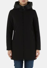 Cappotto nero con cappuccio imbottito, cerniera frontale e tasche laterali. Realizzato in tessuto liscio, maniche leggermente strutturate, design fino al ginocchio.