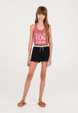 Rode mouwloze tanktop met grafisch ontwerp, zwarte shorts met groene trekkoord en bruine sandalen. Gladde stof en casual pasvorm.
