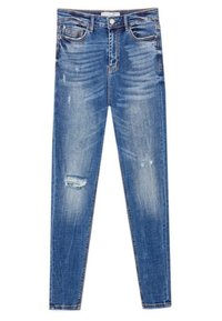 Smal blå jeans gjorda av denim, med en slitna design som har fransade lappar, ljus blekning och klassisk femficksstil.