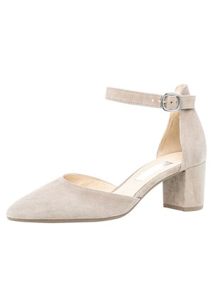 Zapato de tacón de ante beige con punta afilada, tira en el tobillo con hebilla plateada y tacón bajo de bloque. Textura suave y diseño discreto.