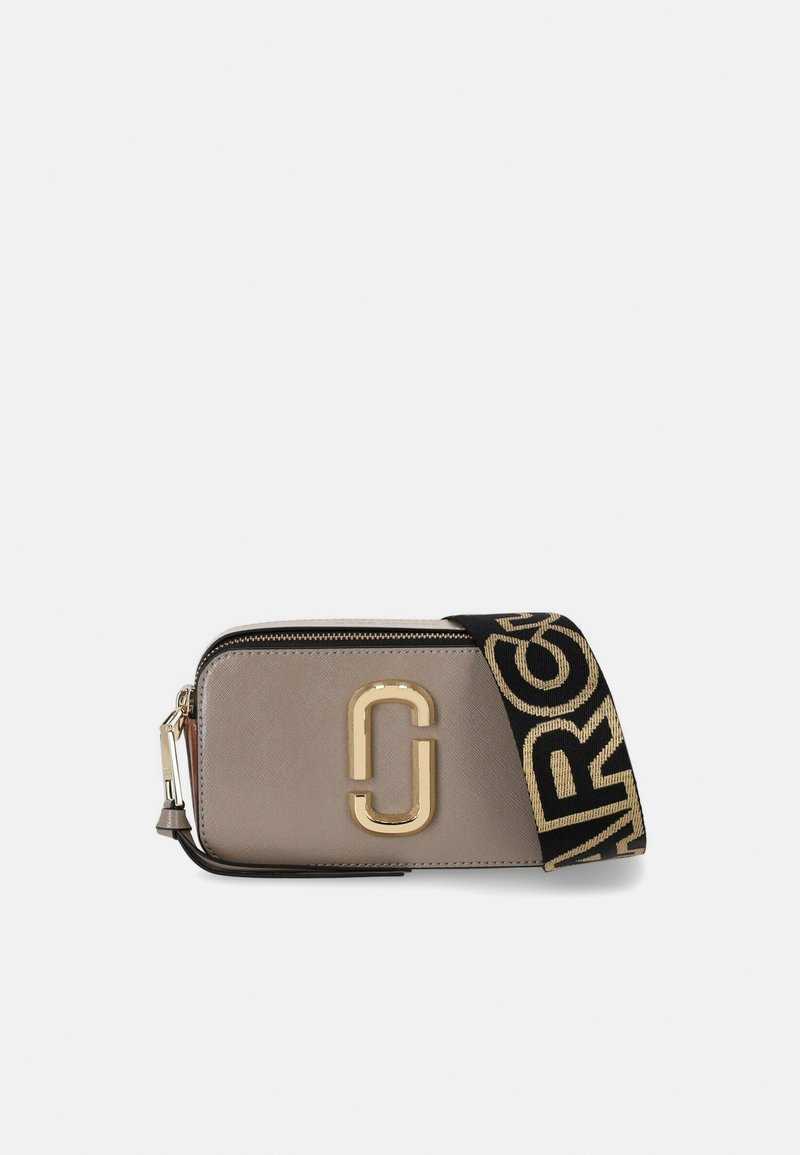 Bolsa de mão em caqui com logotipo em tom dourado, fecho de zip e uma alça tecida riscada com letras em contraste. Material de pele sintética texturizada.