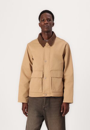 Beige jacket with a brown corduroy collar, snap button closure, and two front pockets. Fabric appears sturdy with a smooth texture.