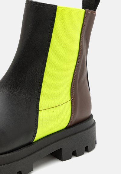 Stivaletto alla caviglia in pelle nera e tessuto giallo neon con dettagli marroni e suola in gomma nera spessa caratterizzata da un motivo battistrada.