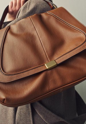 Sac à main en cuir marron avec une finition texturée, grand rabat de fermeture et accent en métal doré. Des lignes courbes rehaussent son design.