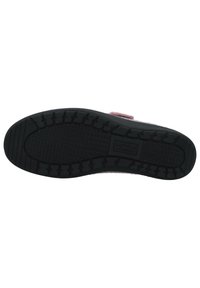 Black rubber sole with textured grip pattern, featuring a raised logo and contrasting pink upper material with a velcro strap.