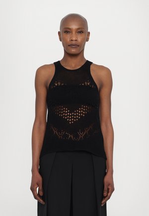 Débardeur en tricot noir avec un design à col halter. Présente des motifs ajourés et une texture semi-transparente. Se marie avec un pantalon noir plissé.