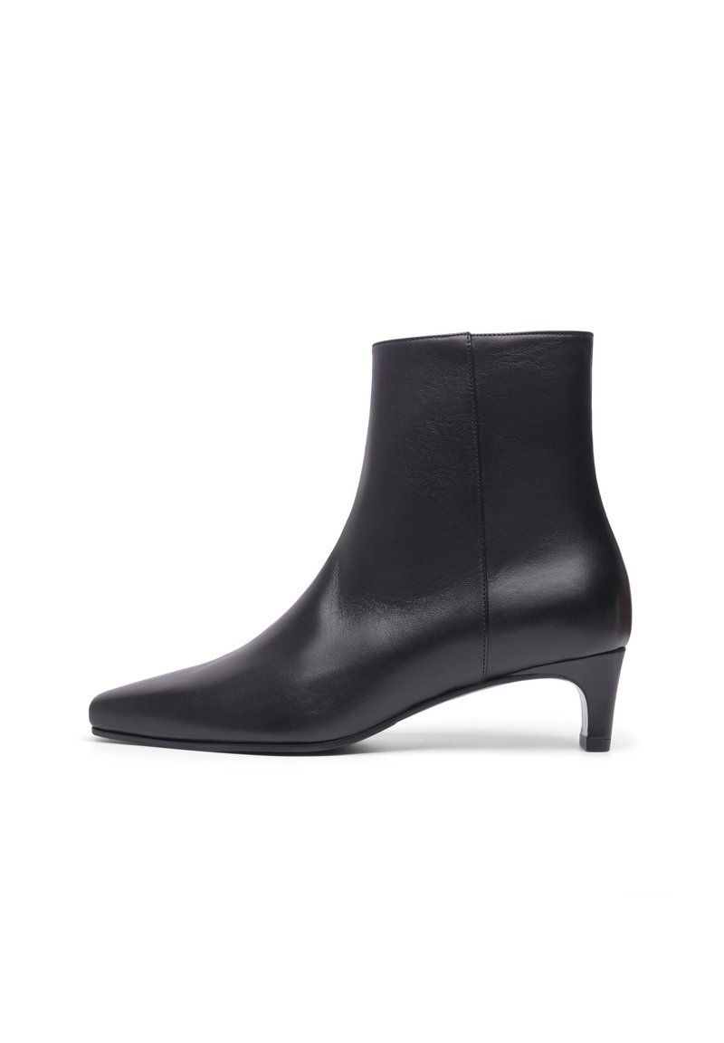 Bottines en cuir noir avec un bout pointu, texture lisse et un talon modeste, présentant un design épuré sans quincaillerie ni accents visibles.