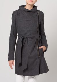 Grauer Wollmantel mit hohem Kragen, asymmetrischem Reißverschluss, gebundenem Taillengürtel und seitlichen Taschen, mit einem ausgestellten Schnitt.