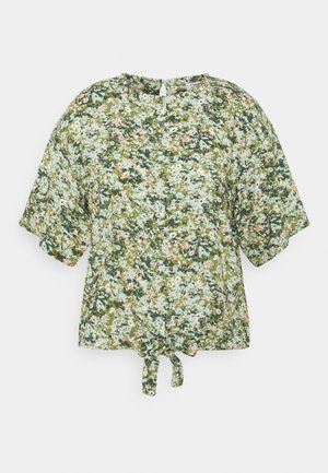 Short-sleeve floral top in green, featuring a tie at the waist, round neckline, and a textured pattern of pink and cream flowers on a light background.
