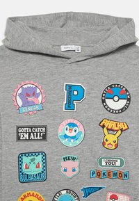 Felpa grigia con diverse grafiche colorate a tema Pokémon, includendo personaggi come Gengar, Pikachu e Bulbasaur, insieme a elementi testuali.