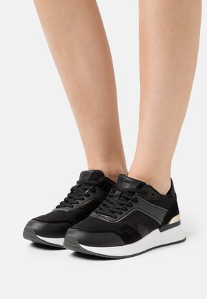 Schwarze Sportschuhe mit Mesh-Obermaterial, Schnürdesign, kontrastierenden silbernen Akzenten, strukturierter Sohle und gepolstertem Kragen für Komfort.