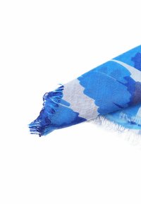 Sciarpa blu che presenta una miscela di diverse sfumature di blu con un bordo frangiato. Realizzata in tessuto leggero, mostra un motivo ad acquerello.