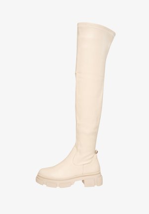 Botas de cuero de color blanco sucio hasta la rodilla, con una textura suave, suela de plataforma gruesa y punta redondeada. Con un tirador trasero para facilitar el uso.